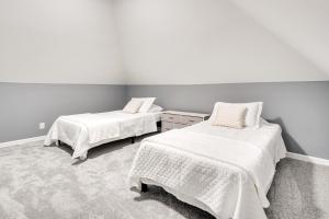 two beds in a room with white walls and carpet at Columbus Vacation Rental about 4 Mi to Downtown! in Columbus
