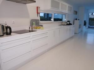 a white kitchen with white cabinets and a sink at White beach luxury vila in Sagres