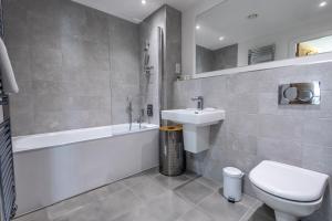 a bathroom with a sink and a toilet and a bath tub at Seaview West Coast - Exceptional - 2 Bedrooms Sleeps 5 -Stunning Sea Views - 500 metres to Beach in Bournemouth