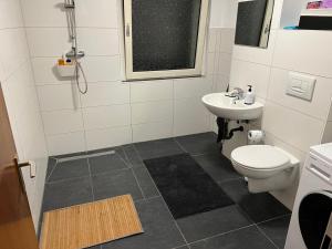 a bathroom with a toilet and a sink at A&V Apartments Sweet Home in Gelsenkirchen