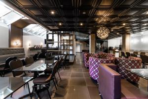 um restaurante com mesas e cadeiras e um bar em Empire Suites em Montreal