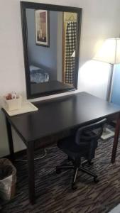 a desk with a mirror and a chair in a room at OSU 2 Queen Beds Hotel Room 132 Wi-Fi Hot Tub Booking in Stillwater