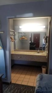a bathroom with a sink and a mirror at OSU 2 Queen Beds Hotel Room 132 Wi-Fi Hot Tub Booking in Stillwater
