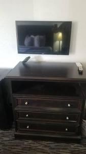 a dresser with a television on top of it at OSU 2 Queen Beds Hotel Room 132 Wi-Fi Hot Tub Booking in Stillwater