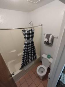 a bathroom with a black and white shower curtain and a toilet at OSU 2 Queen Beds Hotel Room 132 Wi-Fi Hot Tub Booking in Stillwater
