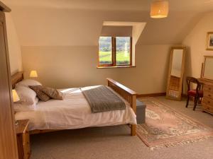 a bedroom with a bed and a window at Pentrego Isaf in Meifod