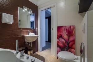a bathroom with a flower painting on the wall at Apartments Marco Polo in Rab +15 photos