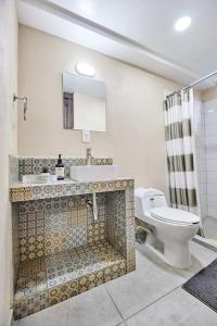 een badkamer met een toilet, een wastafel en een spiegel bij LUXURY STUDIOS AT CASONA 46 in Mexico-Stad