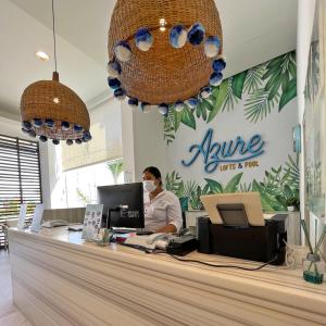 uma pessoa com uma máscara atrás de um balcão numa loja em Azure Lofts & Pool em San Andrés