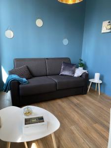 uma sala de estar com um sofá preto e uma mesa em Marianne 4 em Bergerac