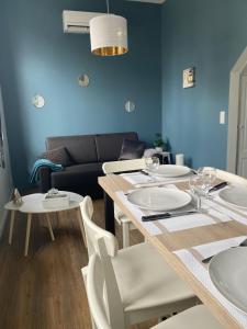 uma sala de jantar com uma mesa e cadeiras e um sofá em Marianne 4 em Bergerac