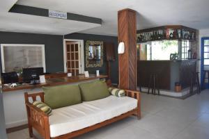 a living room with a couch and a bar at Hibiscus Center in Búzios