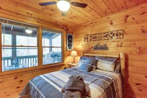 ein Schlafzimmer mit einem Bett in einer Blockhütte in der Unterkunft Blue Ridge Cozy Cabin in the Woods with Hot Tub! in Blue Ridge