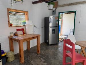 a kitchen with a refrigerator and a wooden table at El Chirris Tzanjay in San Juan La Laguna