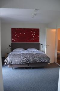 a bedroom with a bed with a large red headboard at Hotel Schlafschön in Hannoversch Münden