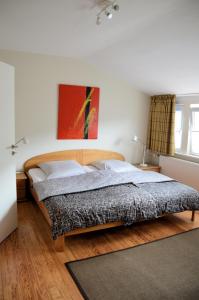 ハノーファーシュ・ミュンデンにあるHotel Schlafschönのベッドルーム1室(ベッド1台付)が備わります。壁には絵画が飾られています。