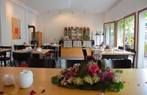 ein Esszimmer mit Tischen und Blumen auf dem Tisch in der Unterkunft Hotel Schlafschön in Hannoversch Münden