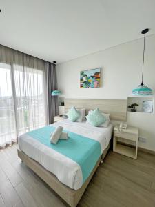 a bedroom with a large bed with a blue blanket at Azure Lofts & Pool in San Andrés