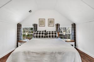 ein Schlafzimmer mit einem großen Bett mit zwei Fenstern in der Unterkunft Bear Creek Cabin, Hot Tub, WIFI, Cozy Cabin Retreat in the Smokies Comfort & Fun for All in Sevierville