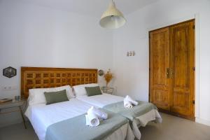 een slaapkamer met een groot wit bed en handdoeken bij VILLA CLAVERO SEVEN Premium Apt in Málaga