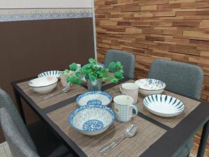 a wooden table with blue and white dishes on it at CEO2 Soho Business Suite#Netfix#USM #PISA#Airport#Pantai Hospital in Bayan Lepas