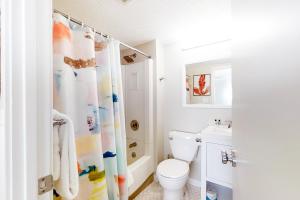 a bathroom with a toilet and a shower curtain at Captains Court 1004 in Fernandina Beach