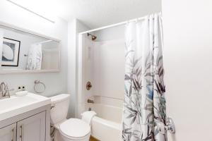 a white bathroom with a toilet and a sink at Captains Court 1004 in Fernandina Beach