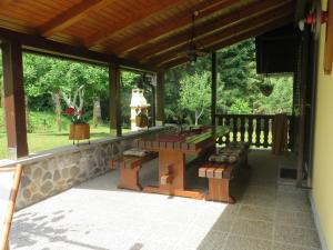 un porche cubierto con mesa y bancos en Family friendly house with a parking space Kuzelj, Gorski kotar - 20980, en Kuželj