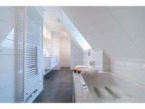 un bagno bianco con vasca e lavandino di Villa in Zeeland with Outdoor Jacuzzi a Colijnsplaat Altre 29 foto