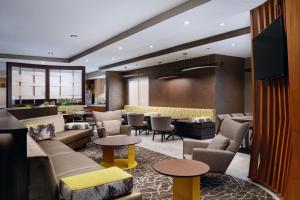 a lobby with couches and tables and a bar at SpringHill Suites Edgewood Aberdeen in Bel Air