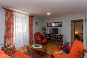 uma sala de estar com mobiliário laranja e uma televisão em Apartments by the sea Kastel Kambelovac, Kastela - 20942 em Kaštela