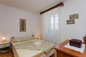 um quarto com uma cama, uma mesa e uma janela em Apartments by the sea Kastel Kambelovac, Kastela - 20942 em Kaštela