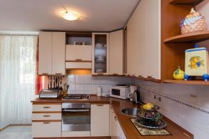 uma cozinha com armários brancos e um lavatório em Apartments by the sea Kastel Kambelovac, Kastela - 20942 em Kaštela