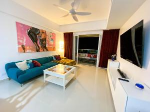 a living room with a blue couch and a table at JUAN DOLIO villa Palmera in Los Corrales