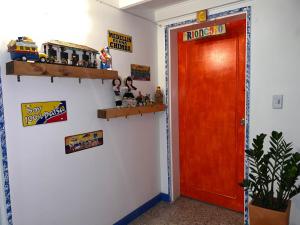 una habitación con una puerta roja y un tren de juguete en la pared en Hostal Casa Guadalupe, en Medellín
