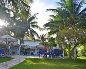 a group of people sitting at a table in a yard at Hibiscus Center in Búzios