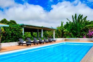 a swimming pool with lounge chairs next to a resort at Enchanted Galapagos Lodge in Puerto Ayora