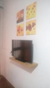 una TV a schermo piatto su una parete con dipinti di CASA ZITO a Cirò Marina