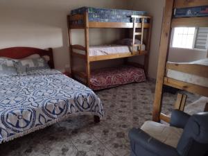 a bedroom with a bed and a bunk bed at Fala Mansa in Itanhaém
