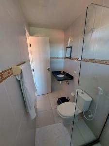 a bathroom with a toilet and a glass shower at Pousada Santo Aleixo in Porto De Galinhas +104 photos