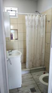 a bathroom with a shower curtain and a sink at Casa con piscina in Maipú