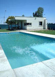 una piscina de agua azul frente a una casa en Casa con piscina en Maipú