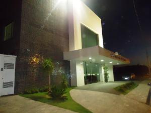 a large building with a sign on it at night at Guines Palace Hotel in Patrocínio
