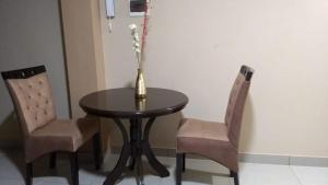 a table and two chairs with a vase on it at LUNATENIS in Pisco