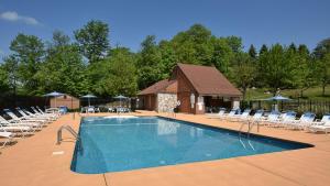 a large swimming pool with chairs and a building at Seven Springs Swiss Mountain 1 Bedroom Standard Condo condo in Champion