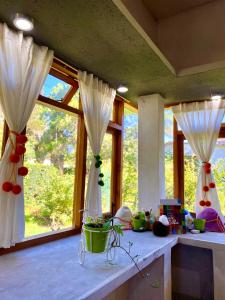 Habitación con ventanas con cortinas blancas y mesa. en La Pichonita en Lozano