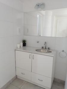 una cocina blanca con fregadero y armarios blancos en Casa hasta 10 personas. en Villa Rumipal