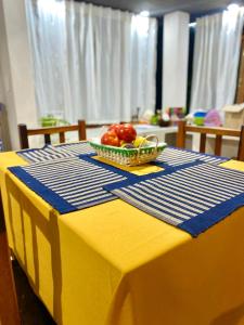 una mesa amarilla con un bol de fruta. en La Pichonita en Lozano