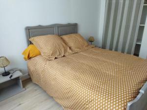 ein Bett mit Polyka-Punkten-Bettwäsche und -Kissen in einem Schlafzimmer in der Unterkunft Le Chapitre in Châteaumeillant