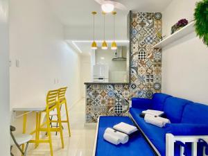 ein Wohnzimmer mit einer blauen Couch und einer Küche in der Unterkunft M30 - Flat a 3 minutos da praia de Copacabana in Rio de Janeiro